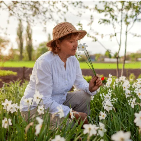 Old woman is smelling the flowers